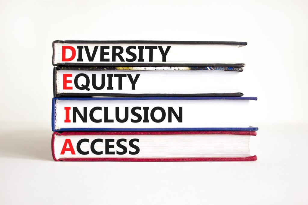 Stack of books labelled Diversity, Equity, Inclusion, and Access, with the initials forming DEIA, reflecting Ottetto’s commitment to inclusive design, equitable environments, and evidence‑based Equity and Diversity Impact Assessments.
