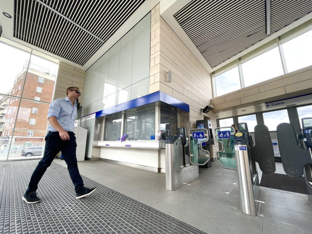 A modern train station ticketing area with staffed and automated access points, including wheelchair‑accessible gates, reflecting Ottetto’s focus on inclusive transport design, equitable passenger flow, and accessible public environments.